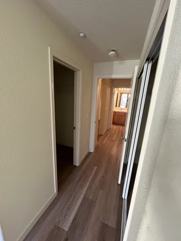a view of a hallway with wooden floor