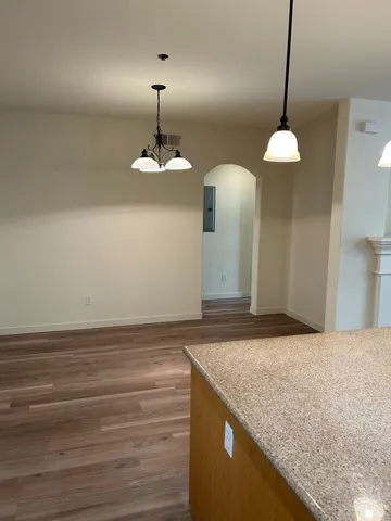 a view of a kitchen counter space with wooden floor and chandelier