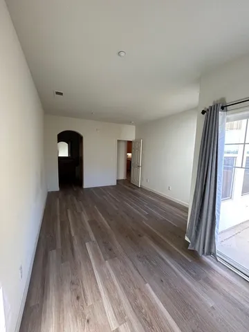 a view of a room with wooden floor and a window