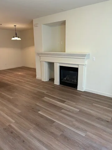an empty room with wooden floor and fireplace