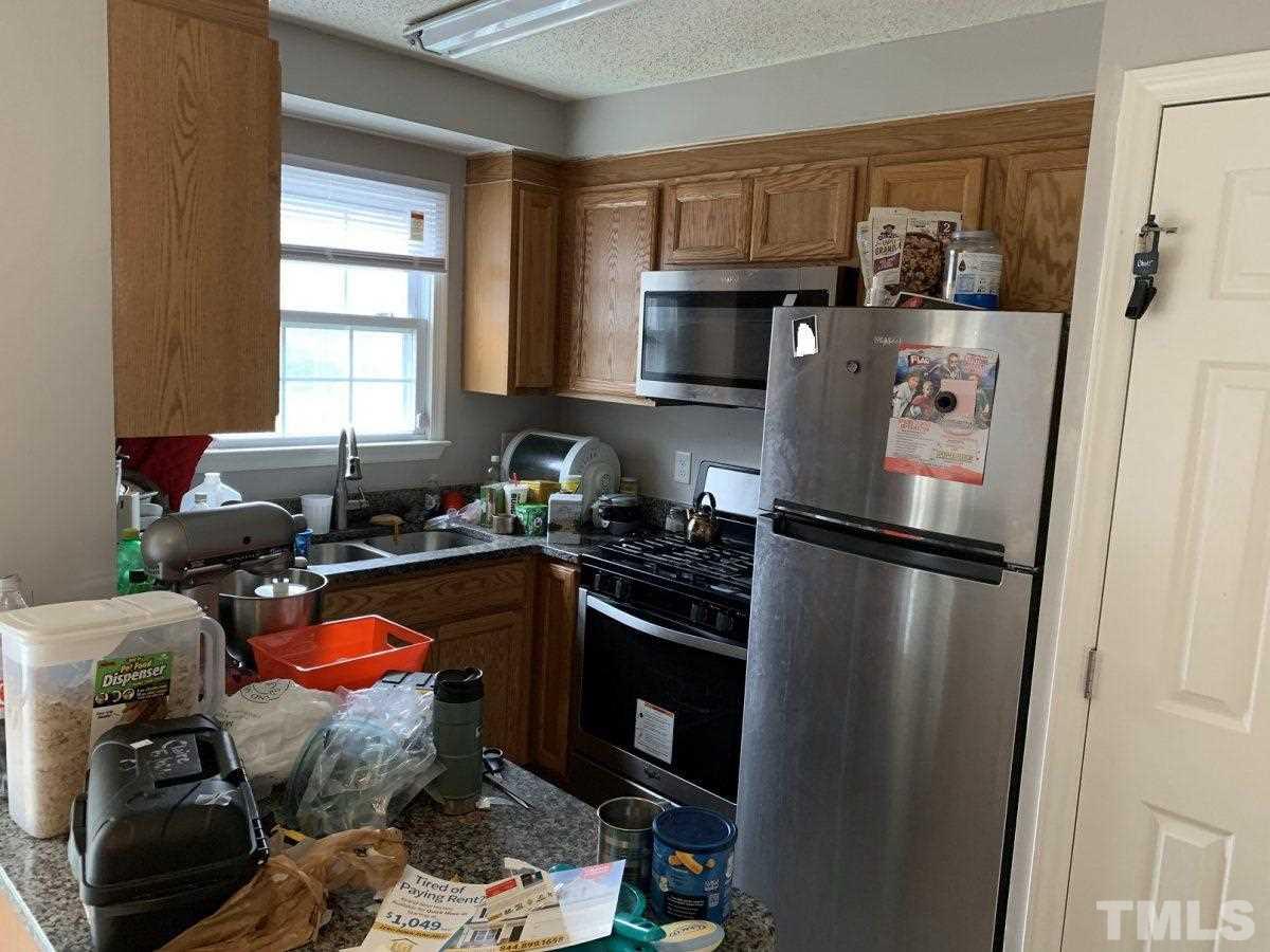 145 Jones Franklin Road, Unit D Raleigh, NC 27606 - Photo 6 of 14 a kitchen with stainless steel appliances a refrigerator a sink a stove and cabinets