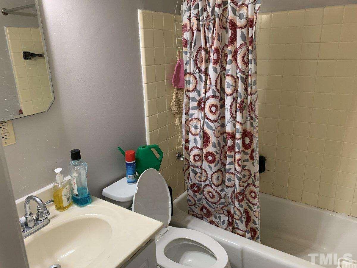 145 Jones Franklin Road, Unit D Raleigh, NC 27606 - Photo 10 of 14 a bathroom with a toilet sink and mirror