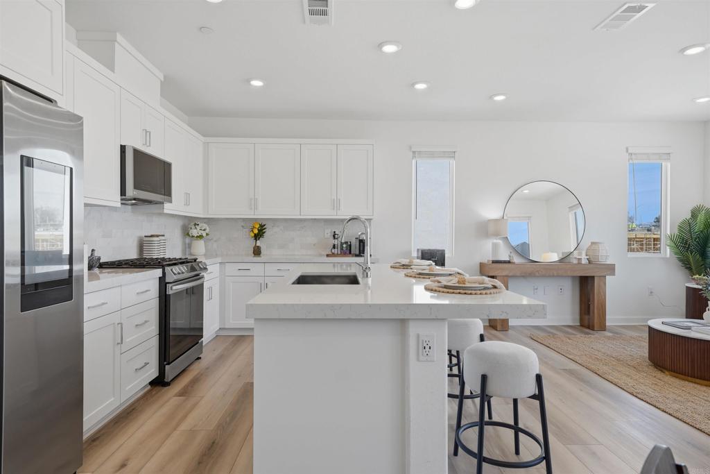 2402 Cascalote Loop San Diego, CA 92154 - Photo 4 of 35 a kitchen with a sink stainless steel appliances and cabinets