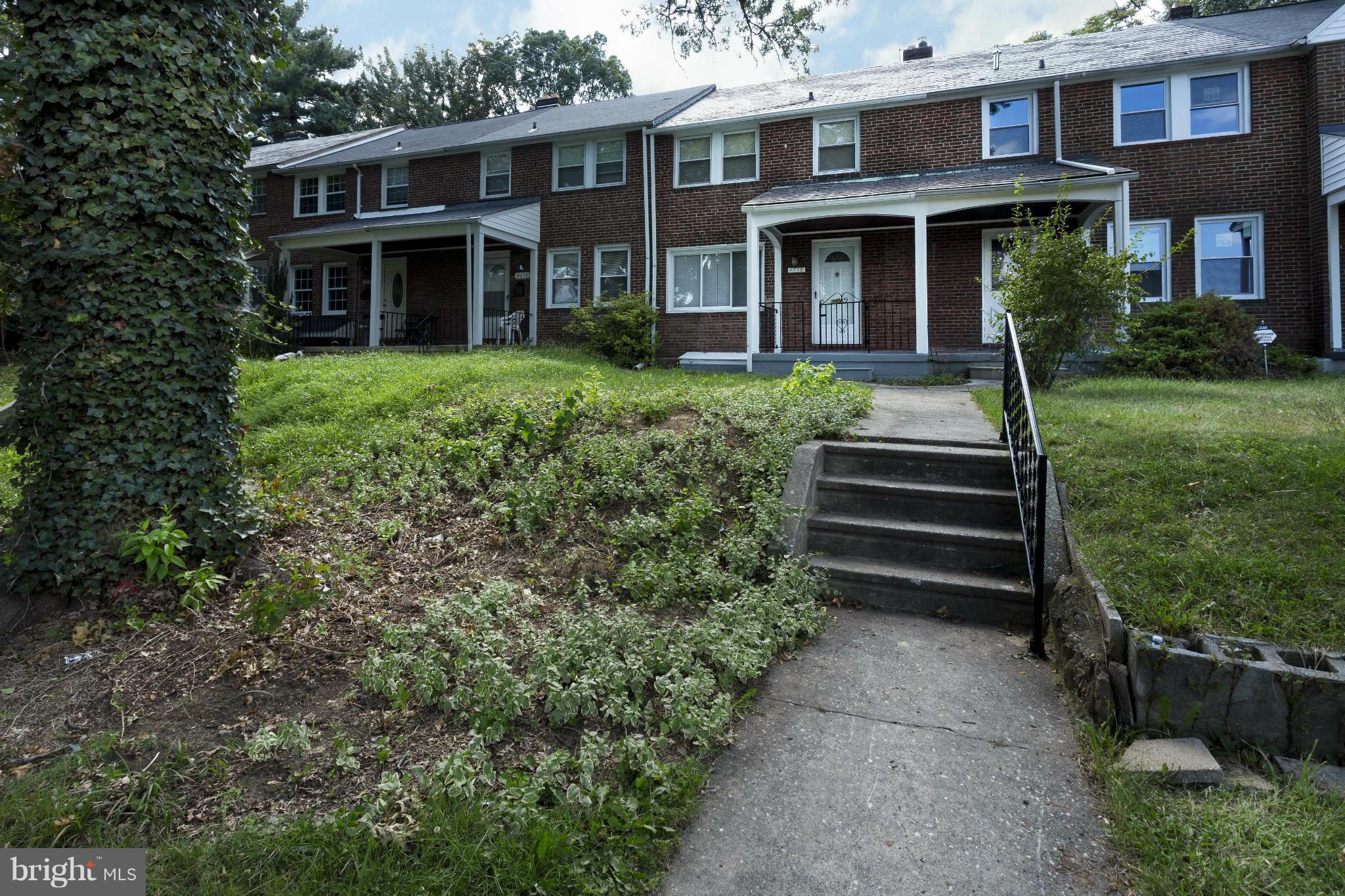 4658 Marble Hall Road Baltimore, MD 21239 - Photo 1 of 23 a view of a brick house with a yard plants and large tree