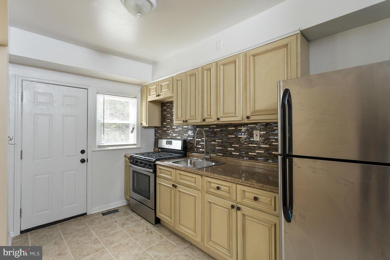 4658 Marble Hall Road Baltimore, MD 21239 - Photo 11 of 23 a kitchen with stainless steel appliances granite countertop white cabinets and a refrigerator