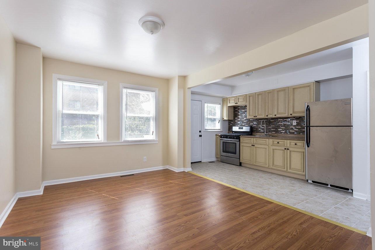 4658 Marble Hall Road Baltimore, MD 21239 - Photo 8 of 23 a kitchen with stainless steel appliances white cabinets and wooden floor