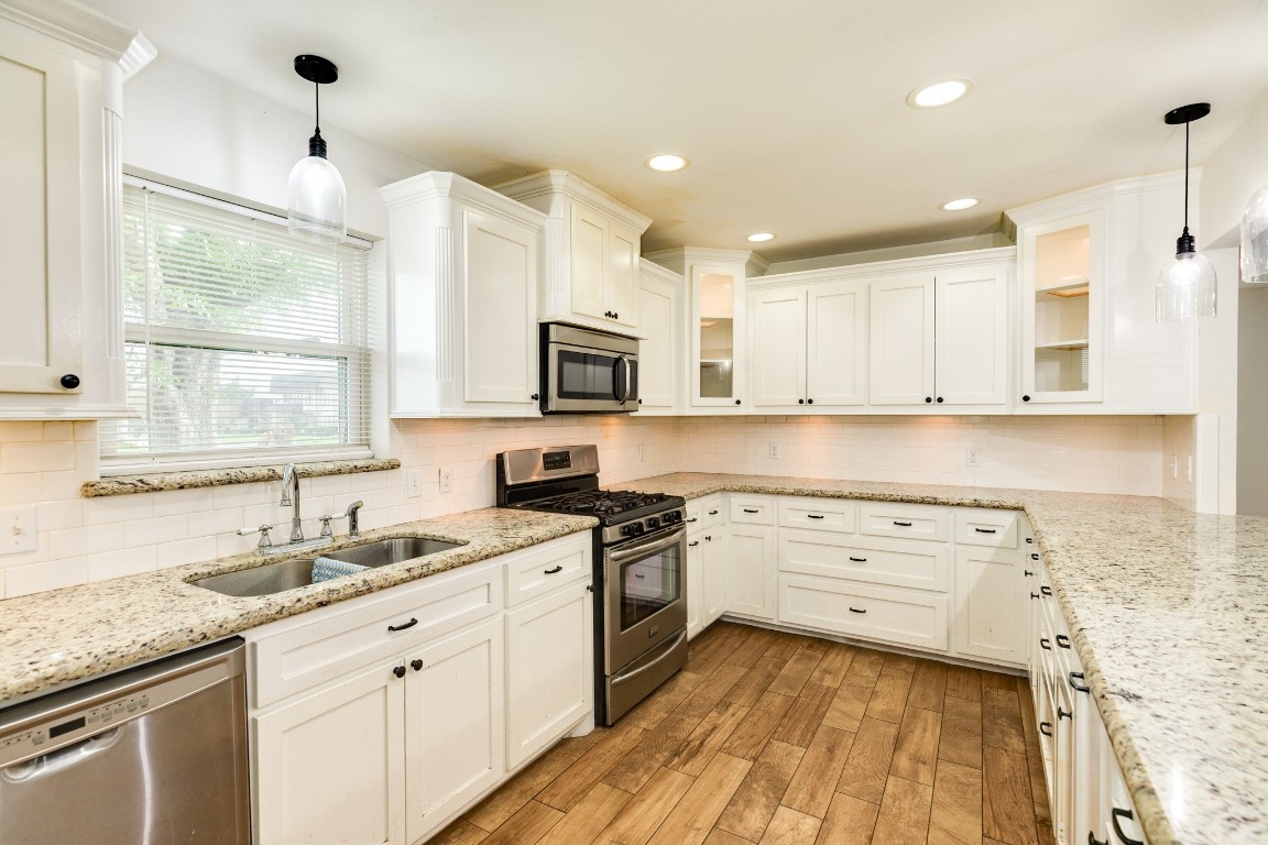 52 South Bachelor Button Street Lake Jackson, TX 77566 - Photo 10 of 45 a kitchen with granite countertop white cabinets and white appliances