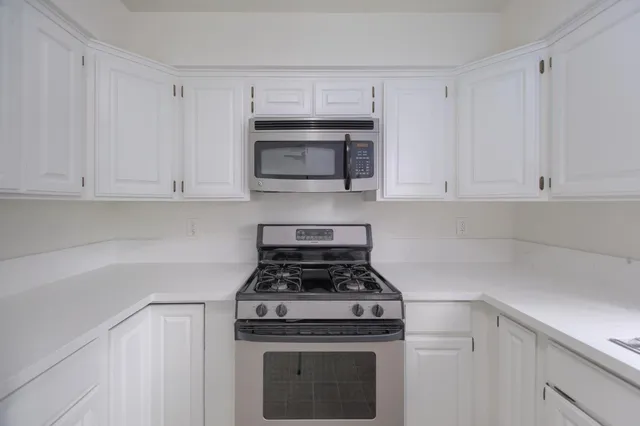 a view of empty room with wooden floor and fireplace