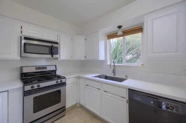 a kitchen with a sink cabinets and window