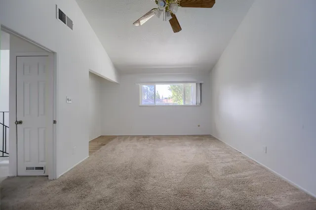 an empty room with fan and entrance