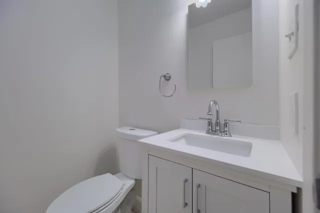 a view of a kitchen with refrigerator and white cabinets
