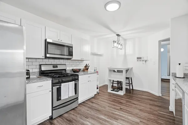 a kitchen with a stove cabinets and wooden floor