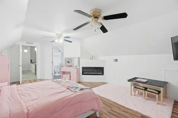 a bedroom with a bed a chandelier and a dresser