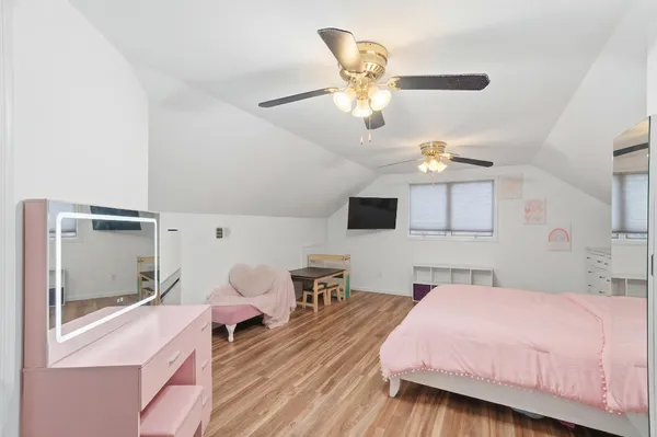 a bedroom with a bed and wooden floor