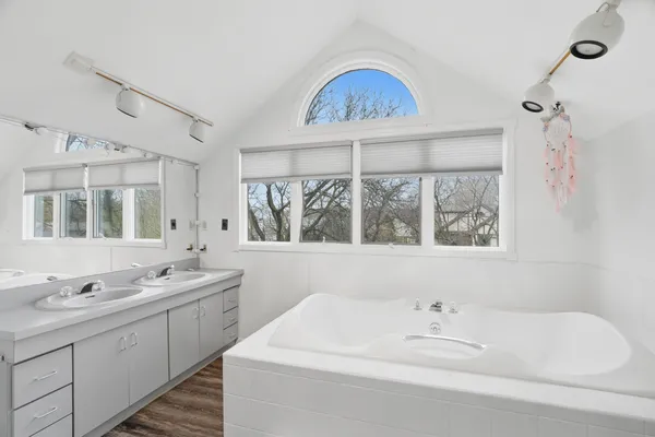 a bathroom with a sink a large mirror and a window