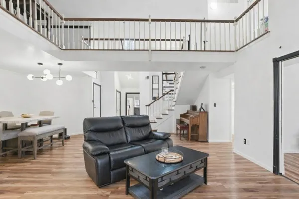 a living room with furniture a wooden floor and a chandelier