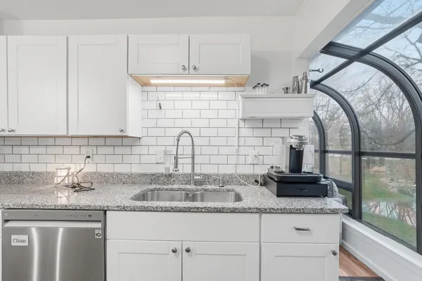 a kitchen with granite countertop a sink a stove and cabinets
