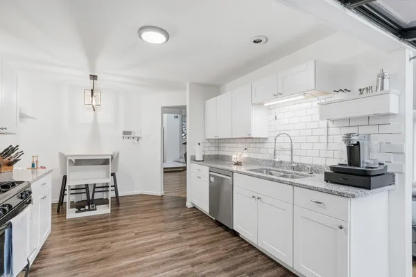a kitchen with a sink cabinets and wooden floor