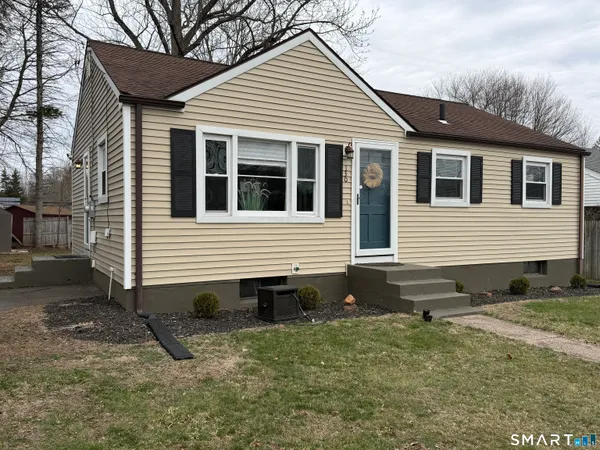 a view of a house with a yard and sitting area