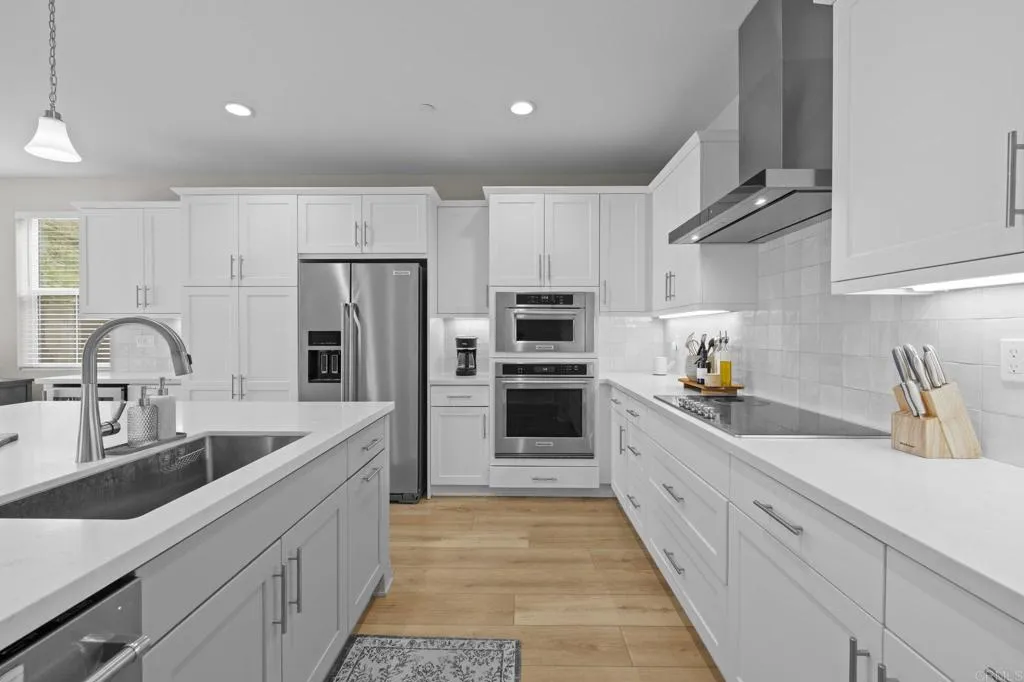 3015 Rue De Latour Vista, CA 92084 - Photo 12 of 48 a kitchen with kitchen island granite countertop a sink stainless steel appliances and cabinets