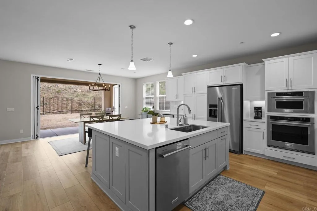 3015 Rue De Latour Vista, CA 92084 - Photo 13 of 48 a kitchen with stainless steel appliances granite countertop a sink a stove and a refrigerator