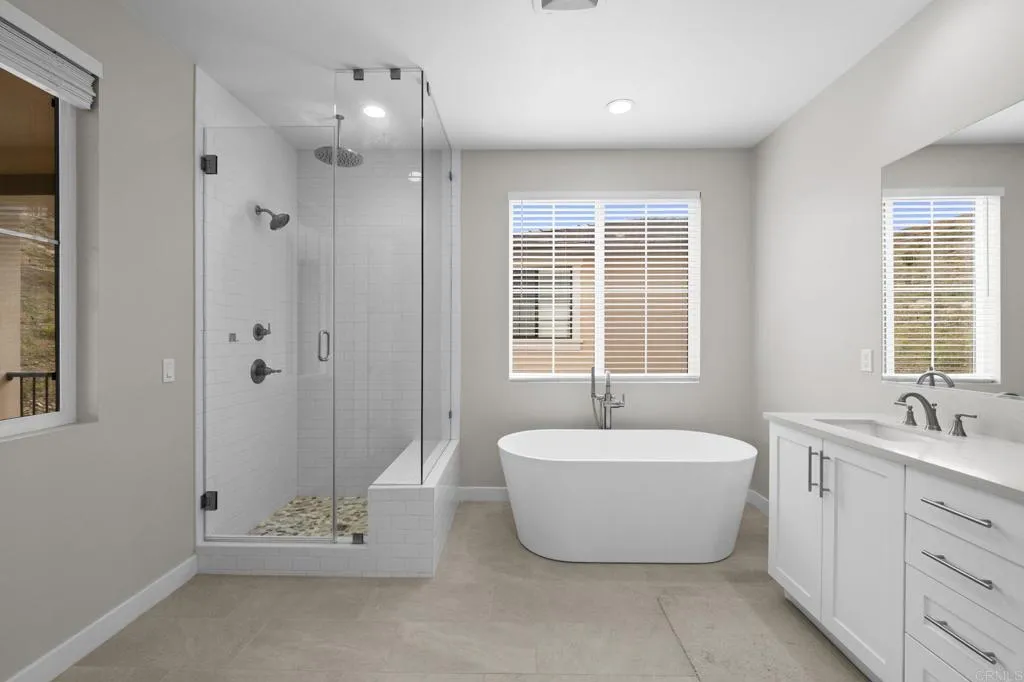 3015 Rue De Latour Vista, CA 92084 - Photo 24 of 48 a spacious bathroom with a tub sink shower and mirror