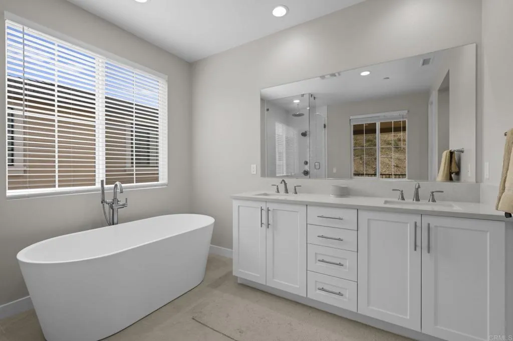 3015 Rue De Latour Vista, CA 92084 - Photo 25 of 48 a spacious bathroom with a double vanity sink large mirror bathtub and window