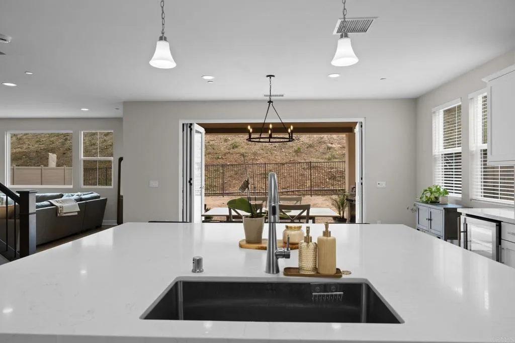 3015 Rue De Latour Vista, CA 92084 - Photo 4 of 48 a kitchen with a faucet a chandelier and living room view