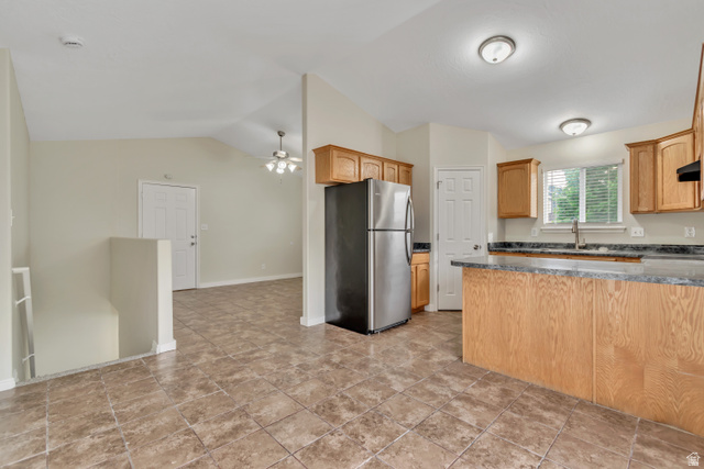 1118 North Ridge Court Spanish Fork, UT 84660 - Photo 13 of 32 Kitchen featuring freestanding refrigerator, a ceiling fan, vaulted ceiling, and exhaust hood