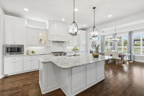 a kitchen with center island white cabinets and stainless steel appliances