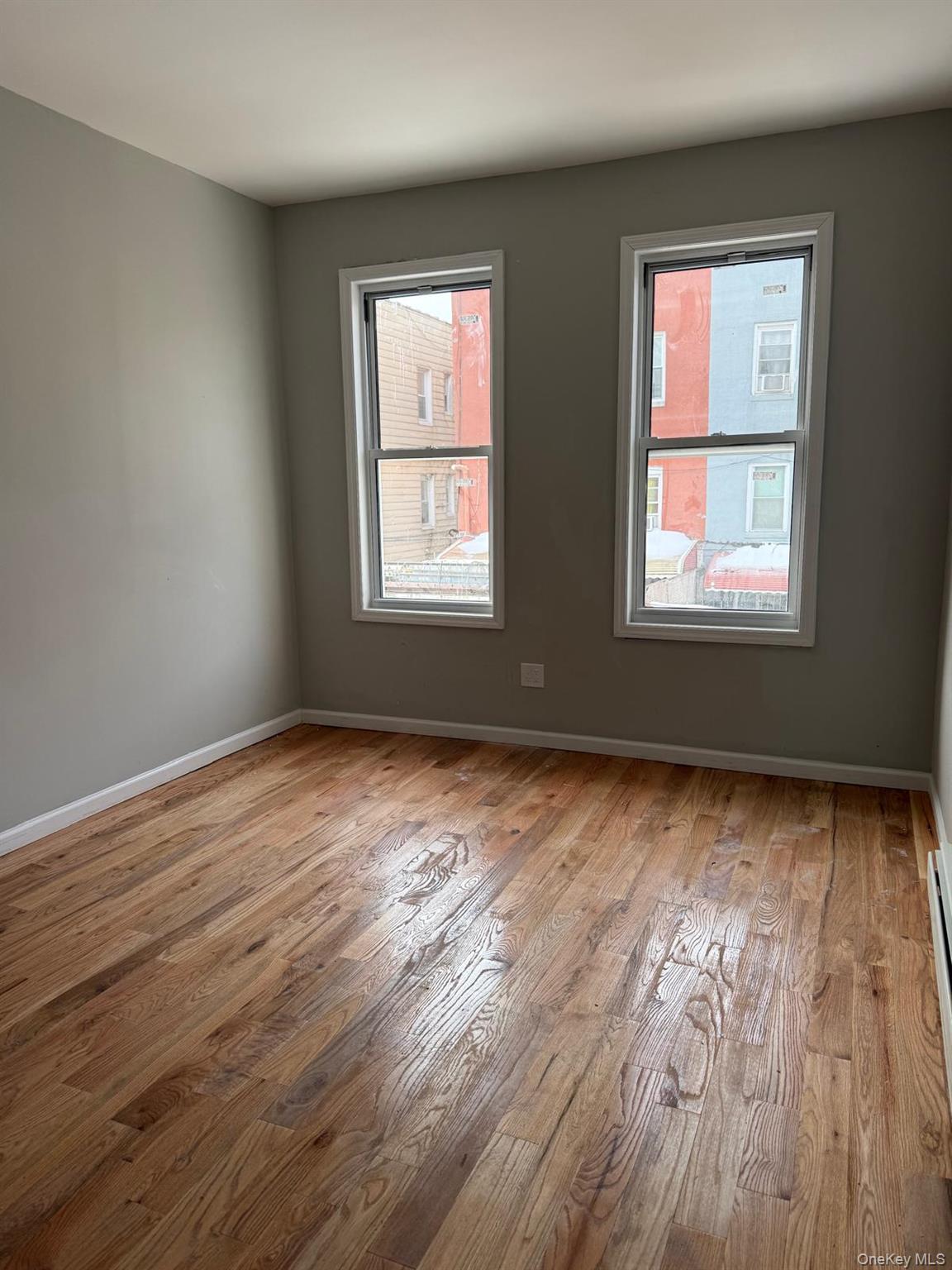 1335 Croes Avenue, Unit 2 Bronx, NY 10472 - Photo 3 of 5 a view of an empty room with wooden floor and a window