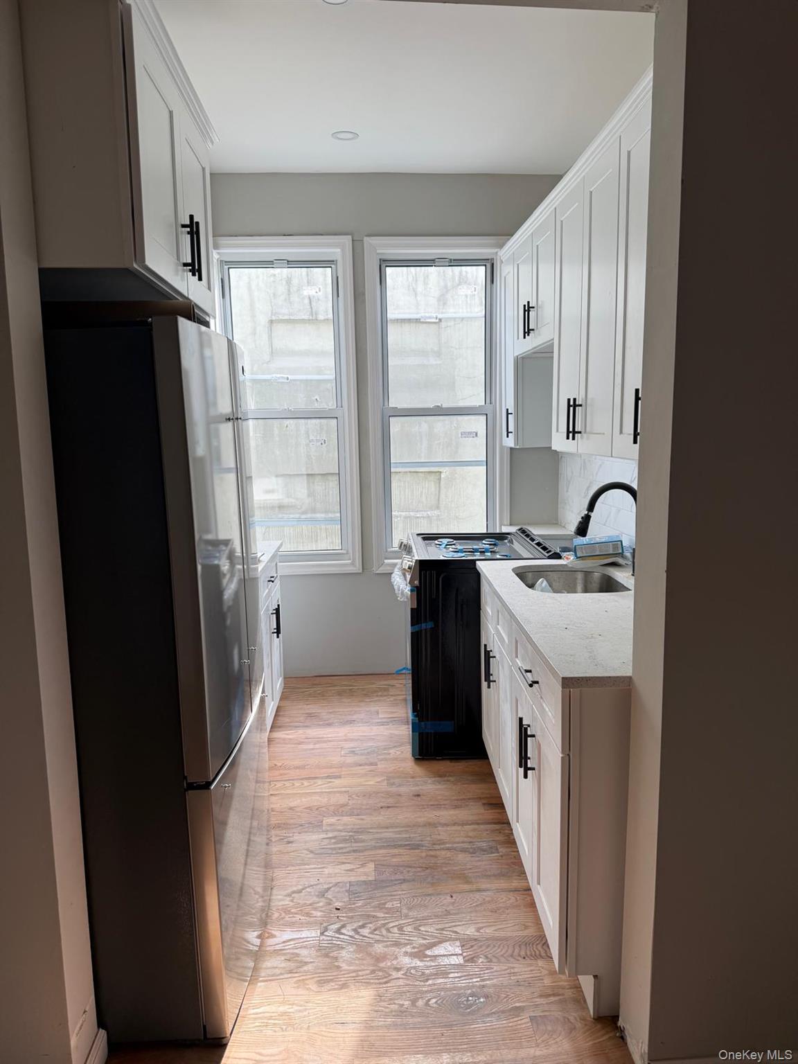 1335 Croes Avenue, Unit 2 Bronx, NY 10472 - Photo 5 of 5 a kitchen with a refrigerator a sink and a window