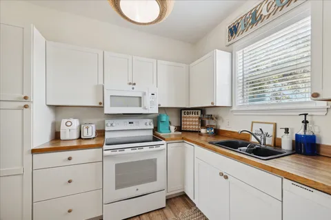 a kitchen with stainless steel appliances granite countertop a sink a stove and cabinets