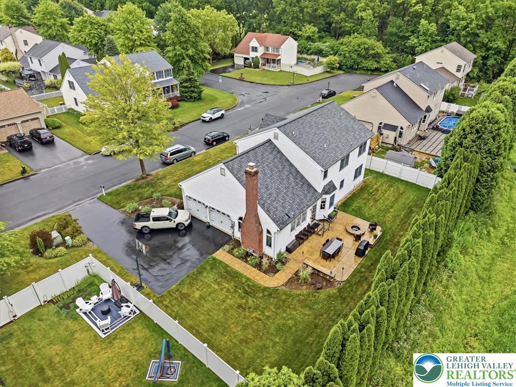 2011 Fieldview Drive Nazareth, PA 18064 - Photo 43 of 52 An aerial perspective showcases a vibrant green yard, a spacious patio, and a well-maintained driveway, embodying classic neighborhood charm.