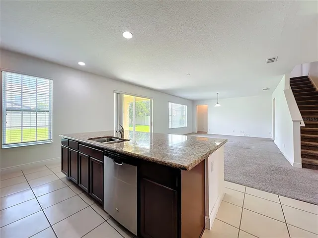 a kitchen with stainless steel appliances granite countertop a stove a sink and a refrigerator