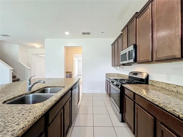 a view of a kitchen with a sink and a refrigerator