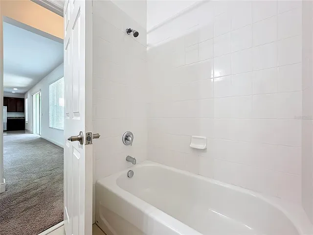 an empty room with windows and entrance to other room