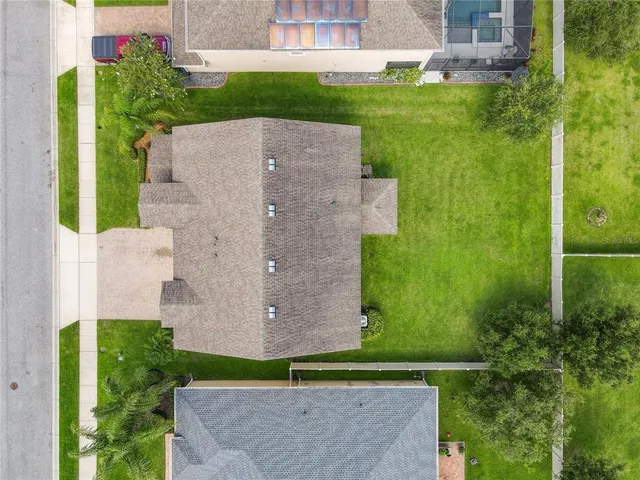 an aerial view of a house with a yard and a large pool