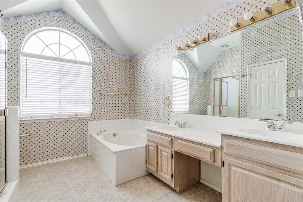 4232 Briarbend Road Dallas, TX 75287 - Photo 12 of 20 a bathroom with a sink a vanity a mirror and a bathtub