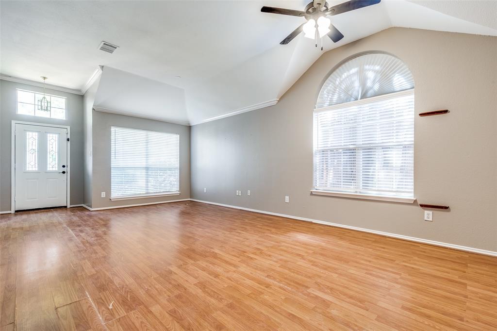 4232 Briarbend Road Dallas, TX 75287 - Photo 6 of 20 an empty room with wooden floor chandelier and windows