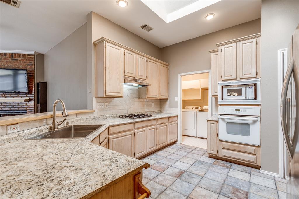 4232 Briarbend Road Dallas, TX 75287 - Photo 7 of 20 a kitchen with granite countertop a sink stove and cabinets