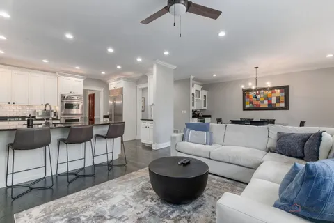a living room with furniture and a view of kitchen appliances