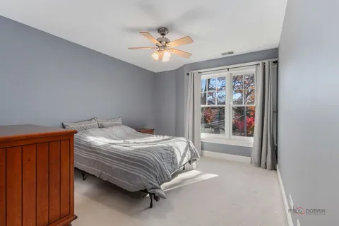 a bedroom with a large bed chandelier and a window