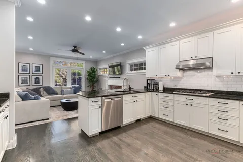 a kitchen with granite countertop white cabinets and white appliances