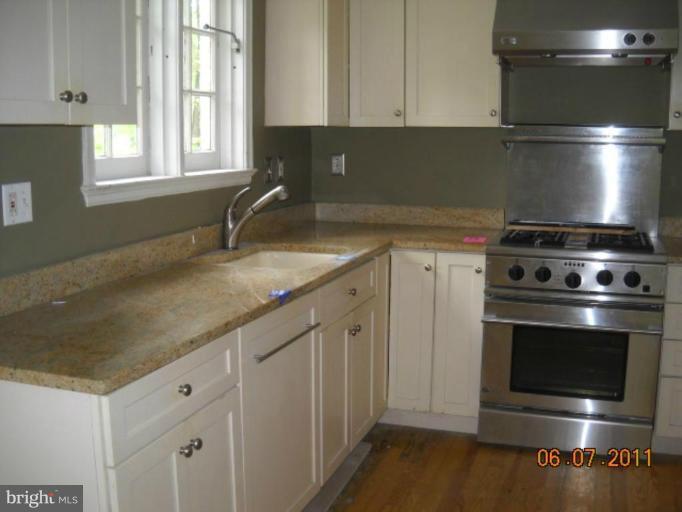 5802 Kenmore Road Baltimore, MD 21210 - Photo 4 of 5 a kitchen with granite countertop a stove sink and cabinets