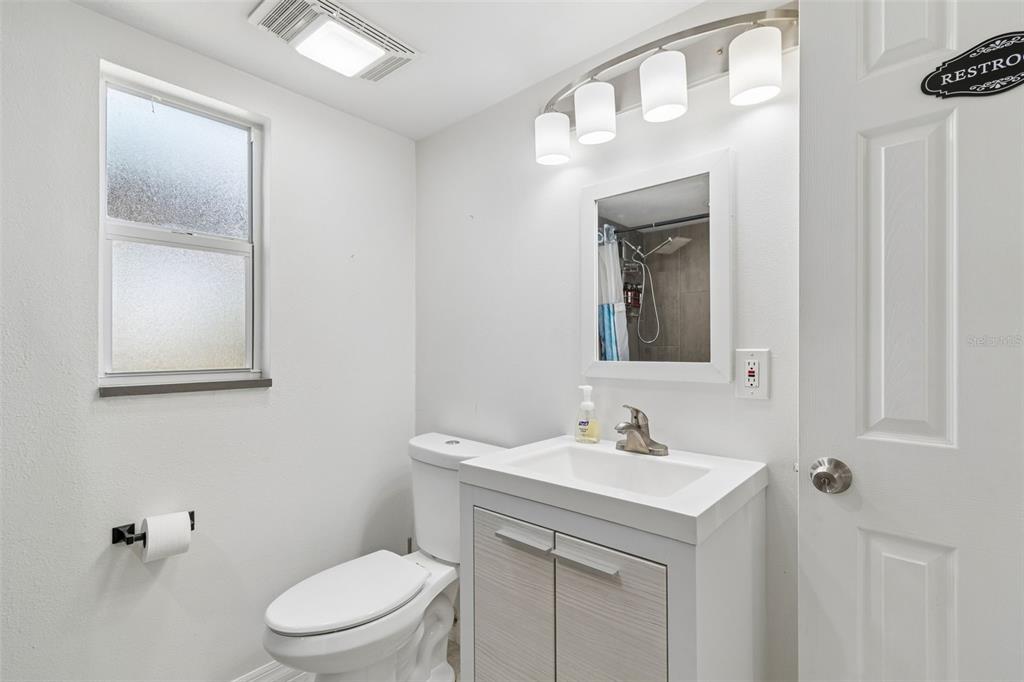 8043 124th Street North Seminole, FL 33772 - Photo 31 of 68 a bathroom with a toilet a sink a vanity and mirror