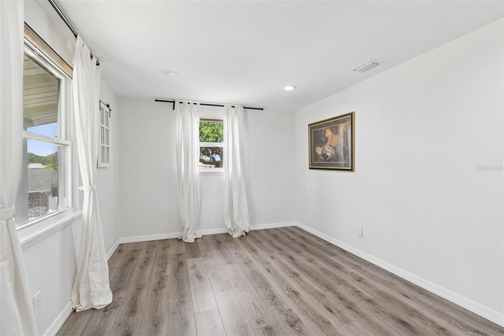 8043 124th Street North Seminole, FL 33772 - Photo 36 of 68 an empty room with wooden floor and windows