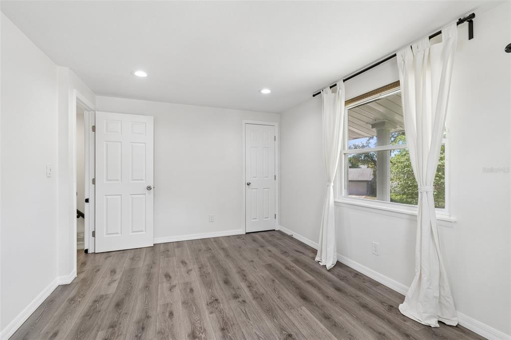 8043 124th Street North Seminole, FL 33772 - Photo 38 of 68 a view of an empty room with wooden floor and a window