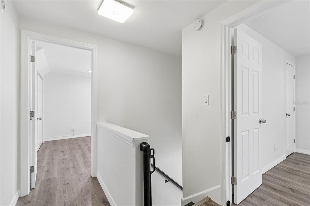 8043 124th Street North Seminole, FL 33772 - Photo 39 of 68 a view of a hallway with wooden floor and staircase