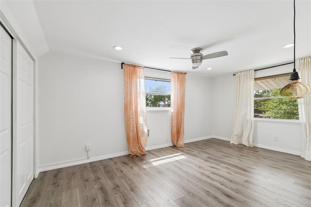 8043 124th Street North Seminole, FL 33772 - Photo 45 of 68 an empty room with wooden floor ceiling fan and windows